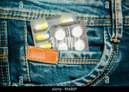 Pillen in Jeans pocket Nahaufnahme. Schutz der Gesundheit Konzept. Stockfoto