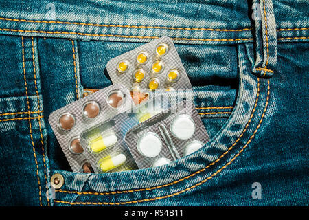 Pillen in Jeans pocket Nahaufnahme. Schutz der Gesundheit Konzept. Stockfoto