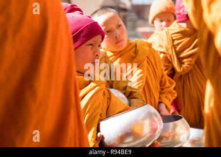 Junge novizin Mönch in Roben, die Almosen Schale in einem buddhistischen Kloster in Kathmandu, Nepal Stockfoto