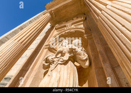 Statue von Mönch mit Kind in den Armen im barocken Außentür der Pfarrei Santa Ana, Wahrzeichen und Denkmal in Penaranda de Duero, Burgos, Kastilien und Le Stockfoto