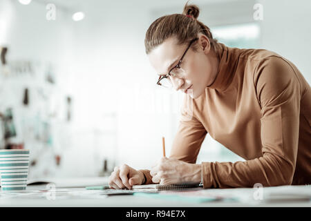 Gutaussehenden jungen blonden Designer von Mode Schule Skizzen machen Stockfoto