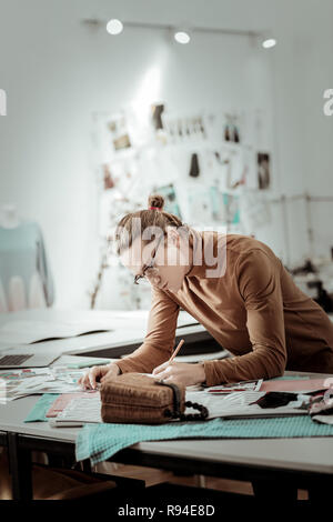 Junge blonde Designer von Mode Schule Zeichnung neue Modelle Stockfoto
