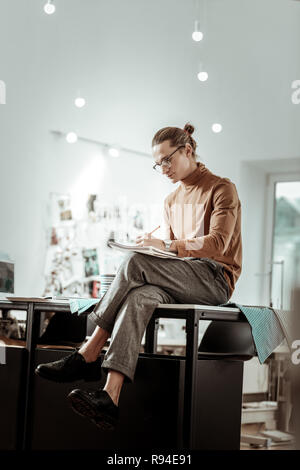 Junge Designer aus Modeschule in schwarze Schuhe der Arbeit in einem Studio Stockfoto