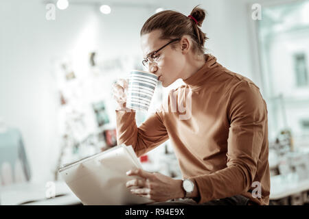 Blonde junge Designer aus Modeschule in schwarze Schuhe Kaffee Stockfoto