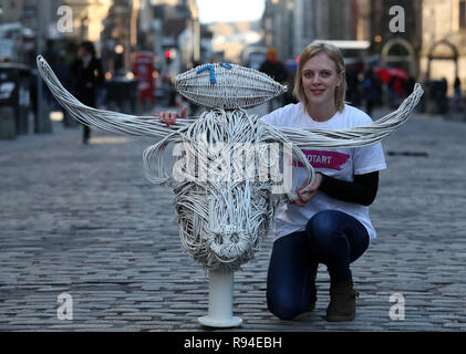 Artist Becca Tait neben einem Highland Kuh mit Rugby 7s Ball auf den Kopf wicker Skulptur, nachdem es in den Innenhof der Stadt Edinburgh Kammern vorgestellt wurde, zeigt verschiedene Symbole, die jede Region in Schottland. Die 14 Skulpturen, die entlang der Royal Mile bis Dezember 29 angezeigt werden. Stockfoto