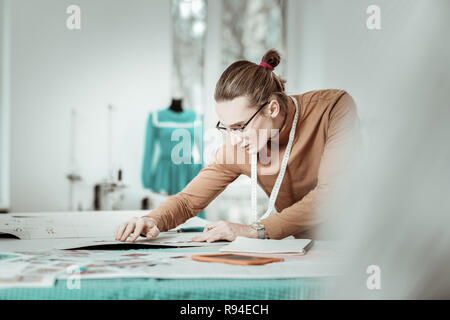Hohe junge Designer aus einer Modeschule in Brillen suchen ernsthafte Stockfoto