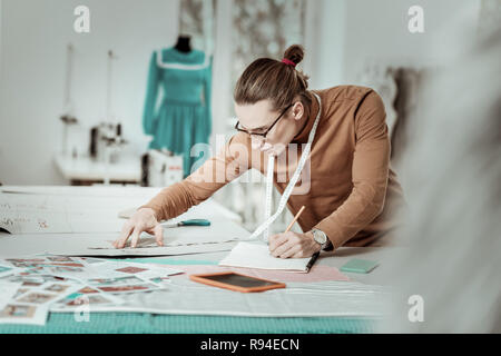 Hohe Langhaarige junge Designer aus einer Modeschule in Brillen suchen Besetzt Stockfoto