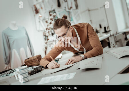 Professionelle Designer aus einer Modeschule mit langen Haaren arbeiten einen neuen Showroom Stockfoto