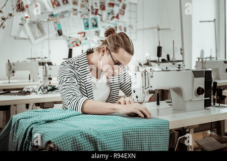 Hübscher junger Modedesigner in eine gestreifte Jacke tun Tailoring Stockfoto