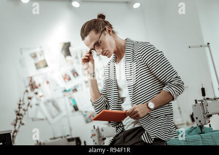 Blonde schöne Mode Designer in seiner Arbeit interessiert Stockfoto