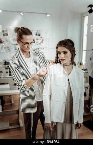 Trendy langhaarigen Fashion Designer arbeiten mit einem schönen Modell Stockfoto