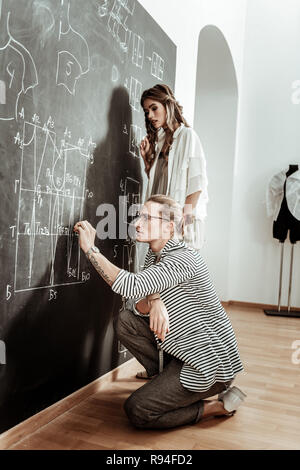 Trendy langhaarigen Designer bei der Suche Brillen beteiligt Stockfoto