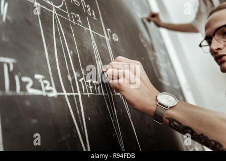 Hübscher junger langhaariger Designer Brillen Suche konzentriert Stockfoto