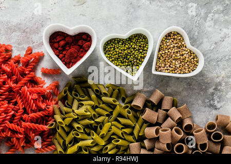 Cognac glutenfreie Pasta mit Zutaten in Schalen in der Form von Herzen, aus der Sie auf einen Tisch aus Stein hergestellt ist Stockfoto