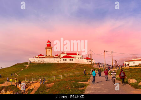 Cabo da Roca, Portugal - 28. März 2018: die Menschen in der Nähe von Leuchtturm am Atlantik, der westlichste Punkt Europas, rosa Sonnenuntergang Stockfoto