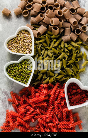 Cognac glutenfreie Pasta mit Zutaten in Schalen in der Form von Herzen, aus der Sie auf einen Tisch aus Stein hergestellt ist Stockfoto