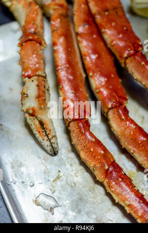 Luxury King snow Crab Claw mit Zitrone am Metallauflagefach auf schwarzem Hintergrund Stockfoto