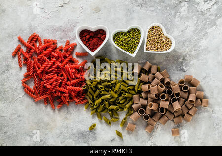 Cognac glutenfreie Pasta mit Zutaten in Schalen in der Form von Herzen, aus der Sie auf einen Tisch aus Stein hergestellt ist Stockfoto