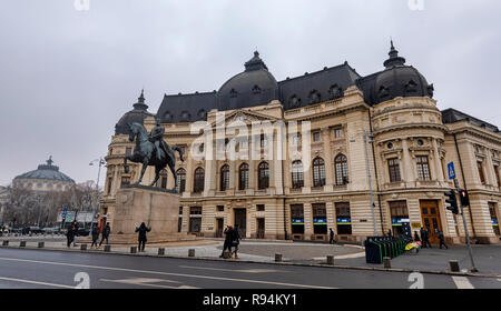 Bukarest, Rumänien - 9. Dezember: Die Biblioteca Centrala Universitara Carol I (Zentrale Universitätsbibliothek Carol I) Am 9. Dezember 2018 in Bukarest, Rumänien gesehen wird. Vor dem Gebäude steht das Reiterstandbild von Carol I (in rumänischer Sprache: eine Ecvestra Statuia lui Carol I). Stockfoto