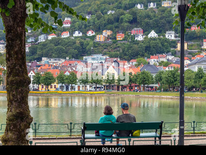 Ehepaar sitzt auf einer Bank in Lille Lungegårdsvannet, einem Park und See im Stadtzentrum, Bergen, Norwegen Stockfoto