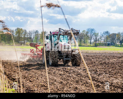 Landwirt pflegen seine Hektar mit seinem Traktor gezogene Egge in der Nähe von Barum, Elbmarsch, Deutschland. Stockfoto