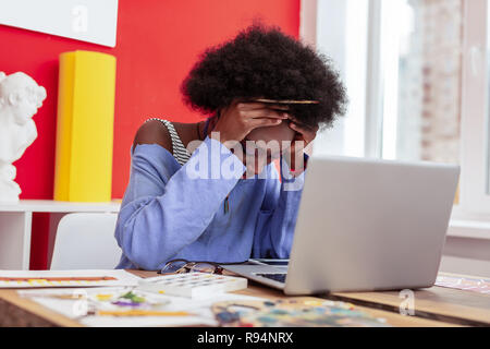 Fashion Designer umklammerte ihren Kopf während Gefühl extrem müde Stockfoto