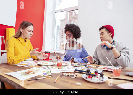 Zwei Auszubildende der Mode Magazin hören auf Ihre team leader Stockfoto