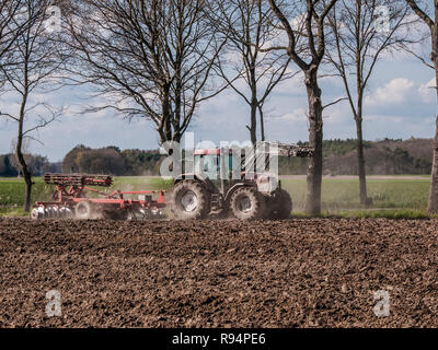 Landwirt pflegen seine Hektar mit seinem Traktor gezogene Egge in der Nähe von Barum, Elbmarsch, Deutschland. Stockfoto