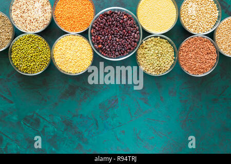 Flach Glasschüsseln mit Superfoods auf strukturierte Smaragd Hintergrund mit Raum fertig zu werden. Stockfoto