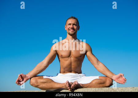 Yoga hilft Balance zu finden und mit der Natur zu vereinen. Yoga hilft, Harmonie und Gleichgewicht zu finden. Mann, Yoga und blauer Himmel. Erreicht Frieden des Verstandes. Meditation und yoga Konzept. Stockfoto