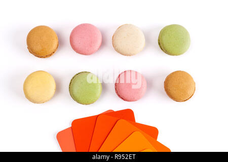 Französische macarons und rot orange Farbmustern auf weißem Hintergrund Stockfoto