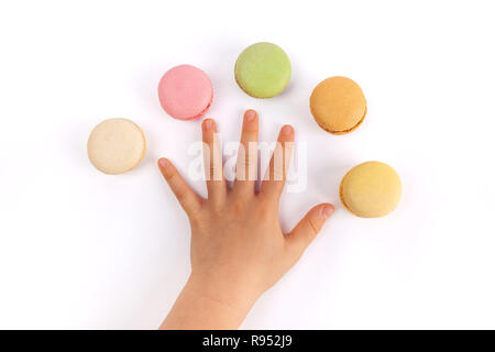 Die Hand des Kindes Verbreitung Finger mit fünf bunte Macarons auf weißem Hintergrund Stockfoto