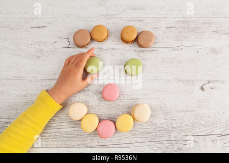 Kind platzieren ein Auge auf Smiley von Macarons mit Kopie Raum Stockfoto