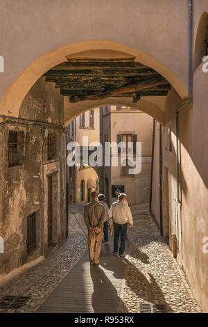 Gruppe von Menschen zu Fuß die Via Plinio il Giovane, Passage im historischen Zentrum von Spoleto, Umbrien, Italien Stockfoto