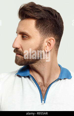 Ernster Mann stehend, an der Kamera auf weißem studio Hintergrund isoliert. Schönes, junges Gesicht. männliche Brustbild. Menschliche Gefühle, Mimik Konzept. Stockfoto