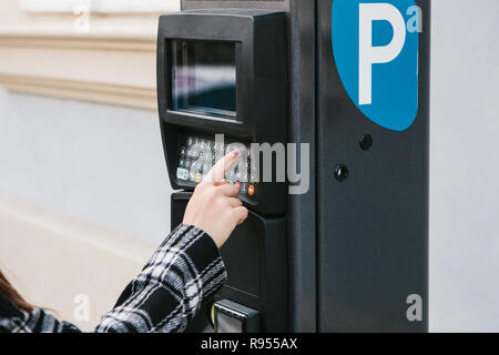 Ein modernes Terminal für das Zahlen für Parkplätze. Die Person drückt die Tasten und zahlt für die Parkplätze. Moderne Technik im Alltag Stockfoto