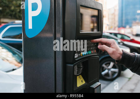 Ein modernes Terminal für das Zahlen für Parkplätze. Die Person drückt die Tasten und zahlt für die Parkplätze. Moderne Technik im Alltag Stockfoto