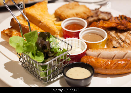 Essen Steaks und Würstchen Sortiment (würzige Huhn, Schwein, Rind, Fisch) serviert mit Pommes und Brot, beidseitig mit verschiedenen Saucen und weit Stockfoto