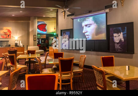 Ein Fernsehen spielt eine endlose Schleife von Elvis Presley's Filme und Konzerte im Heartbreak Hotel auf dem Elvis Presley Boulevard in Memphis, Tennessee. Stockfoto