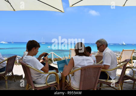 Familie sitzt in einem Restaurant mit Meerblick, Es Calo, Formentera, Spanien Stockfoto