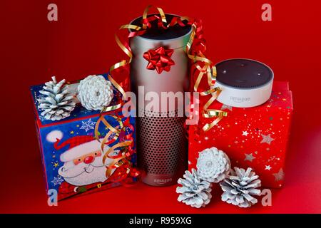 Amazon Echo und Echo Dot mit Weihnachtsschmuck auf rotem Hintergrund Stockfoto