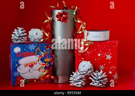 Amazon Echo und Echo Dot mit Weihnachtsschmuck auf rotem Hintergrund Stockfoto