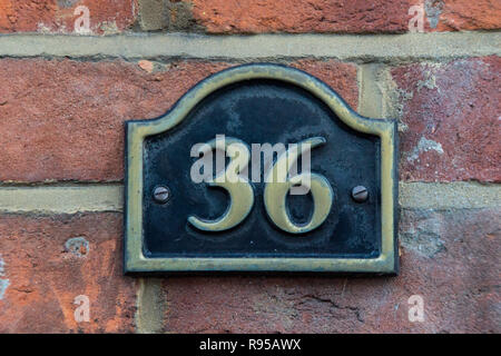 Das Haus Nummer 36 in Messing auf einer roten Wand, Stockfoto