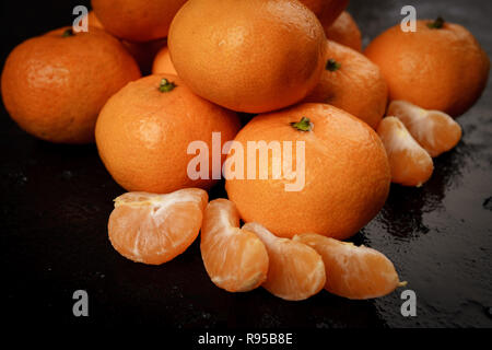 Frisch gepflückt Mandarinen auf schwarzem Hintergrund Stockfoto