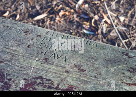 Graffiti auf einer alten Bank aus Holz Stockfoto