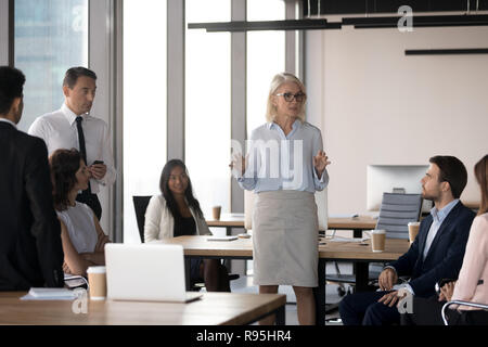 Im mittleren Alter attraktive Ernst Trainer im Gespräch mit Mitarbeitern Stockfoto