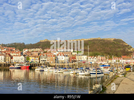Am Yachthafen in Scarborough. Boote im Hafen mit der familienfreizeitszentren und Hügel mit Burgruinen auf hinter vertäut. Stockfoto