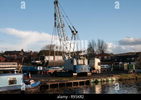 Um die UK-Anheben einer schmalen Boot von einem LKW-Anhänger in den Kanal. Stockfoto