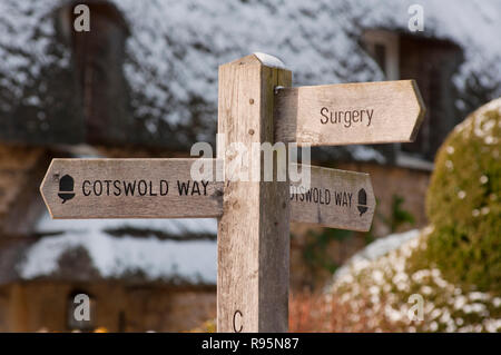 Cotswold Way Wegweiser vor reetdachhaus im Winter Schnee in Chipping Campden. Gloucestershire. England. Stockfoto