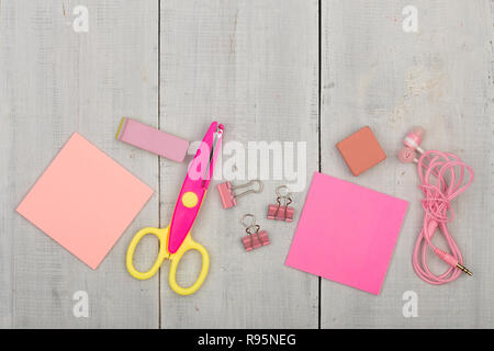 Schulmaterial für Mädchen rosa - Schere, Aufkleber, Radiergummi und anderes Zubehör auf weissem Holztisch Stockfoto